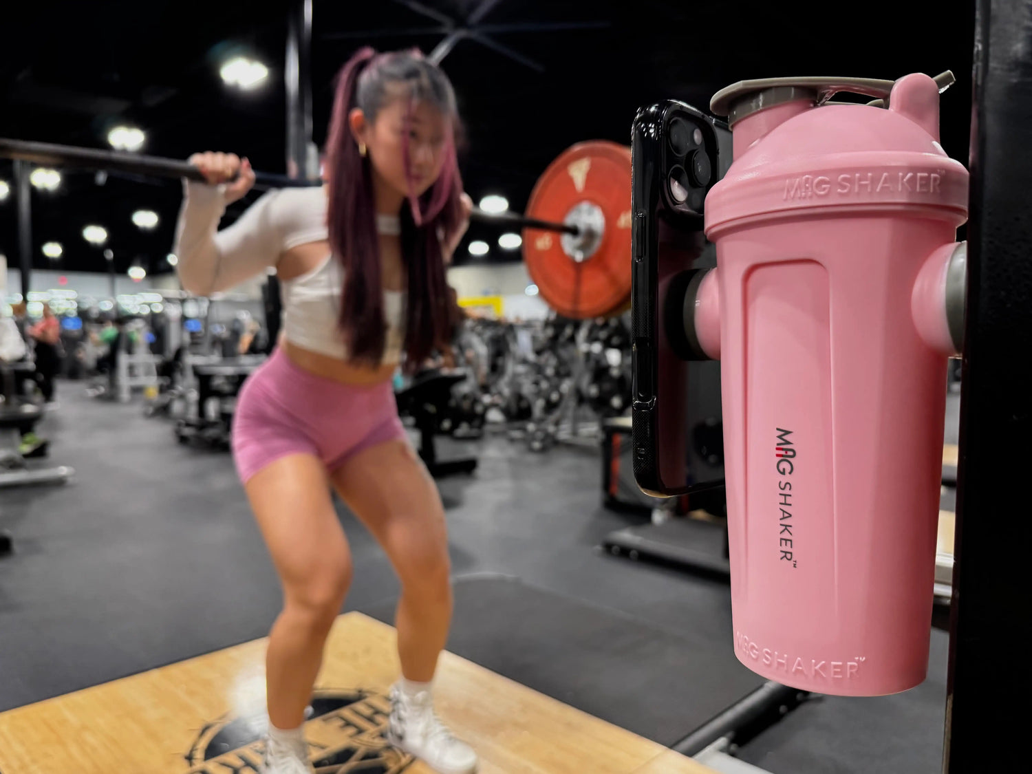 Female squatting with magshaker and phone mounted simultaneously