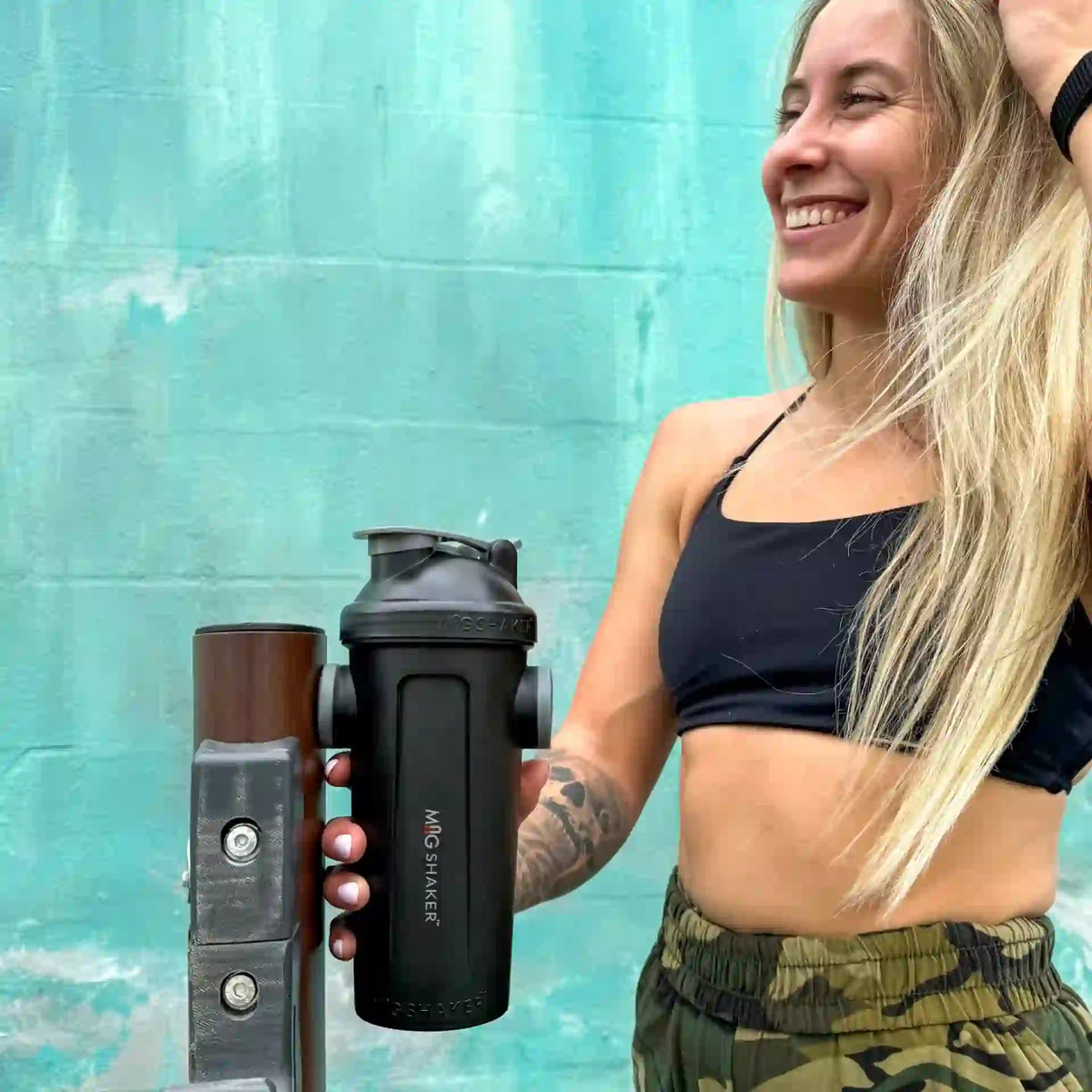 Fit female mounting 28oz black magnetic Mag Shaker bottle on gym equipment